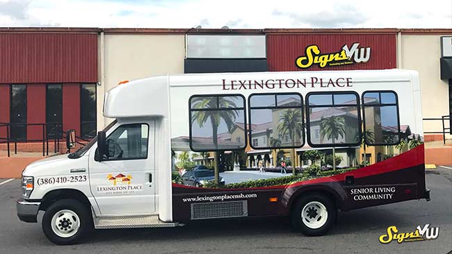 Bus in the foreground of the photo with a full wrap for Lexington Place Senior living Community