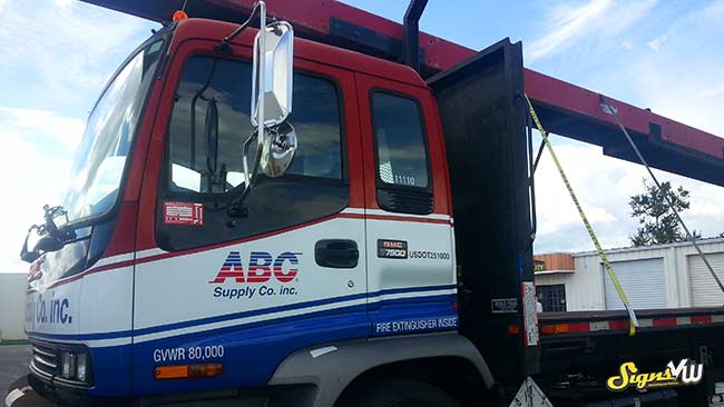 Truck in the foreground of the photo with a full wrap for ABC Supply Co, inc